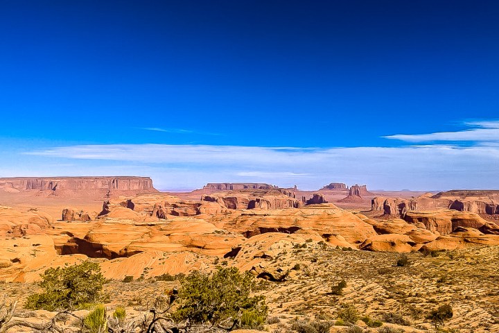 a valley aerial view of the monuments from a distance on top of a mesa